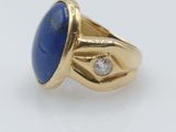 a close up of a gold ring with a lapis stone and diamonds