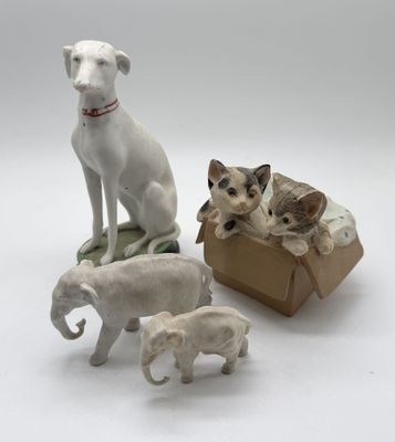 four figurines of dogs and a cat in a box