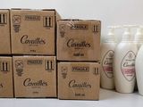 plusieurs flacons de lotion posés sur une table, à côté d'une boîte en carton