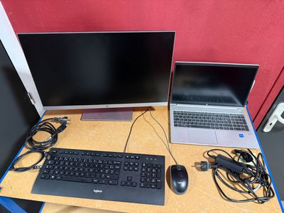 a laptop and a monitor on a desk with a keyboard and mouse