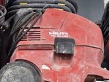 a red lawn mower sitting on top of a shelf next to a pile of other lawn mowers