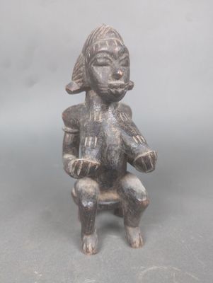 statue représentant un homme assis sur une chaise, coiffé d'un chapeau