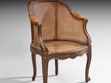 une chaise ancienne à dossier et accoudoirs en rotin