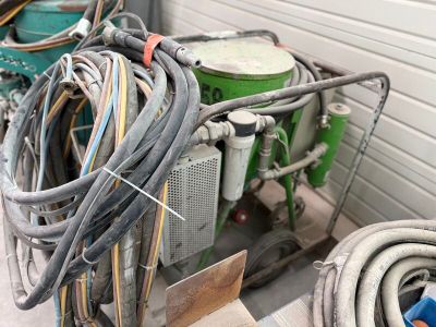 a pile of hoses and other electrical equipment in a garage