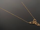 a close up of a gold necklace with a butterfly pendant on it