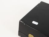 a black box with a gold handle on a white surface
