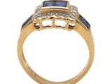 a close up of a gold ring with a sapphire and diamonds