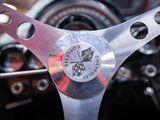 a close up of a steering wheel with a clock on it