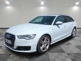 L'Audi blanche est garée sur un sol en carrelage à damier.