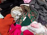a pile of clothes that is sitting on a bed