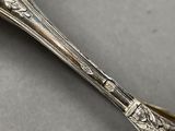 an antique silverware spoon with a flower design on the handle