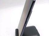 a close up of a phone on a stand on a white surface