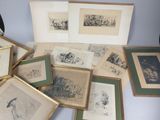 a lot of framed pictures on a table with a cat