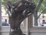 a statue of a woman sitting on a table in front of a window