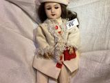 a doll that is sitting on a white sheet
