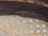 a close up of a chair with a wooden seat and back