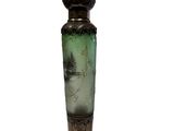 a green vase with a tree on it on a white surface