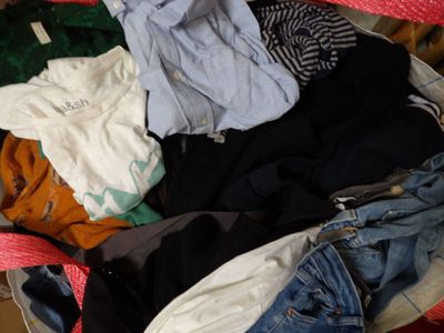 une valise rouge remplie de vêtements et d'un jean