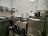 une cuisine équipée d'un évier, d'une cuisinière et d'une poubelle