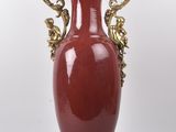 un grand vase rouge orné de motifs dorés