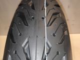 a close up of a motorcycle tire on a wooden surface