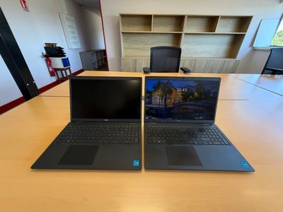 deux ordinateurs portables posés sur une table dans une pièce