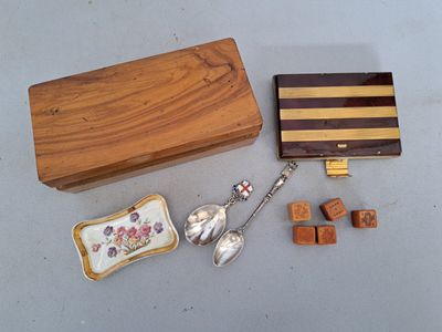 une petite boîte en bois contenant une cuillère, un repose-cuillère et d'autres objets