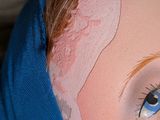 a close up of a doll ' s face with a blue headband