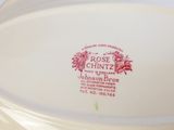 un gros plan d'une assiette blanche sur laquelle est posée une rose rouge