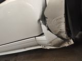 a white car that has a dent in the side of it