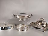silverplated dishes and trays on a table with a white background