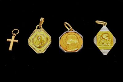 trois médailles d'or et d'argent, ornées d'une croix sur fond noir