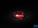 un diamant rouge sur une surface noire