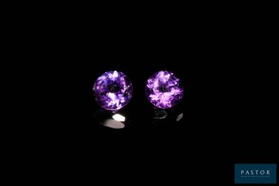 a pair of purple amethtites on a black background
