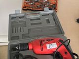 une boîte à outils contenant une perceuse et d'autres outils, posée sur une table