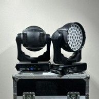 two moving lights sitting on top of a case on top of a table