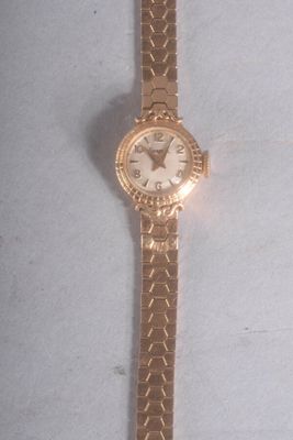une image représentant une montre en or avec un cadran blanc posée sur une surface blanche