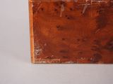a small wooden box with holes in it on a white surface
