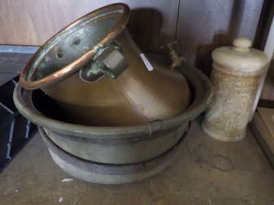 a large metal bowl sitting on a counter next to a bottle