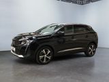 Un SUV noir est garé dans une grande pièce aux murs blancs.
