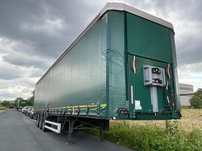 a green semi truck that is parked on the side of the road