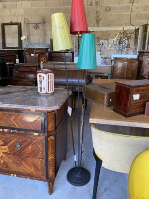 une table sur laquelle est posée une lampe, dans une pièce remplie de meubles