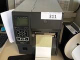 une imprimante posée sur un bureau à côté d'un ordinateur