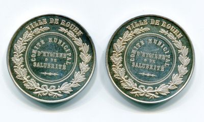 deux pièces d'argent posées côte à côte sur une surface blanche