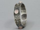 a close up of a silver ring with a pink stone in the middle