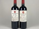 two bottles of red wine sitting next to each other on a table