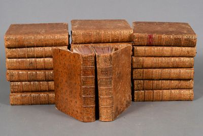 several old books stacked on top of each other on a table