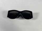 a close up of a pair of black sunglasses on a white surface