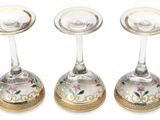 six silver and gold wine glasses with floral designs on them