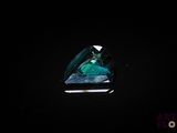a green tourmaline in a triangular cut on a black surface